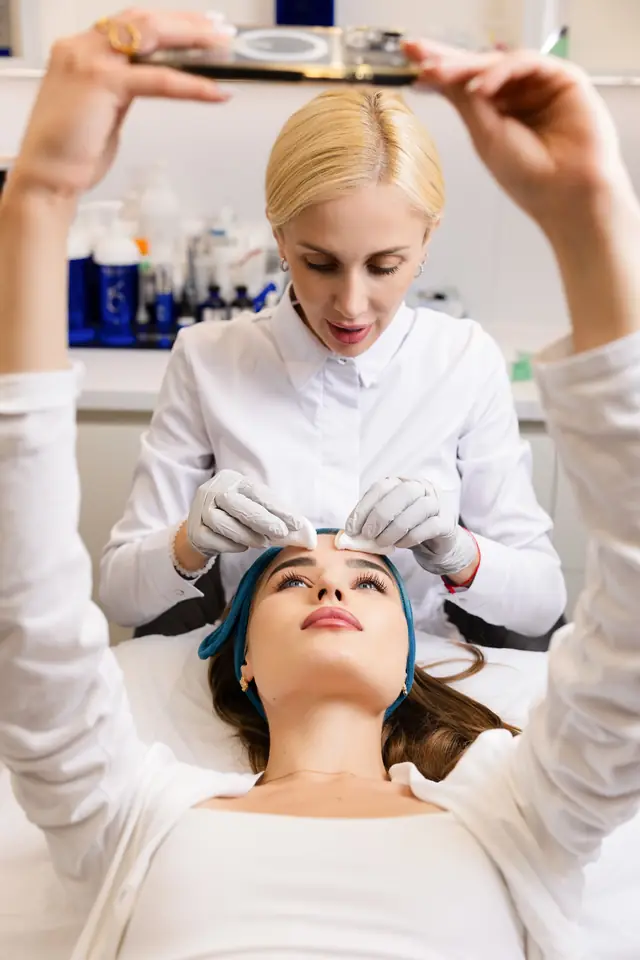 Gloved hands working along the forehead
